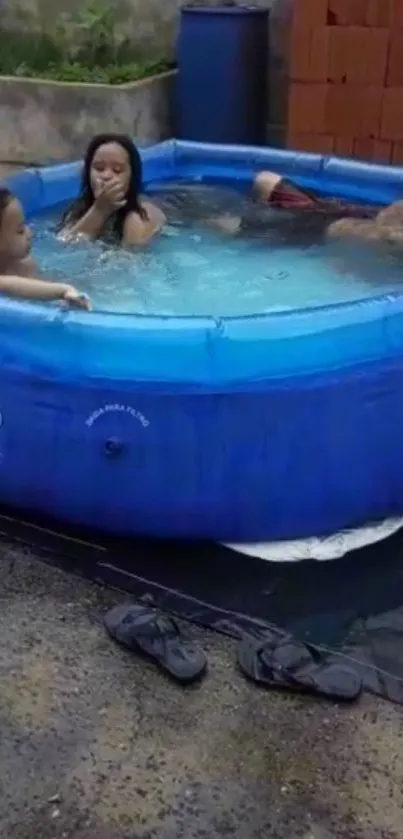 Family enjoying in a blue inflatable pool outdoors.