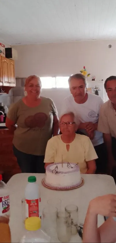 A family celebrating around a cake, smiling warmly in a cozy home setting.