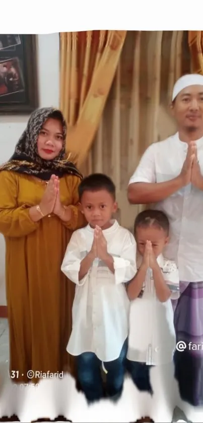 Family in traditional attire, hands joined in gesture.