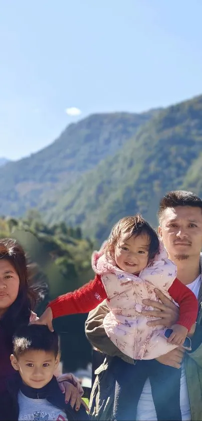 Family posing in front of a scenic mountain landscape.