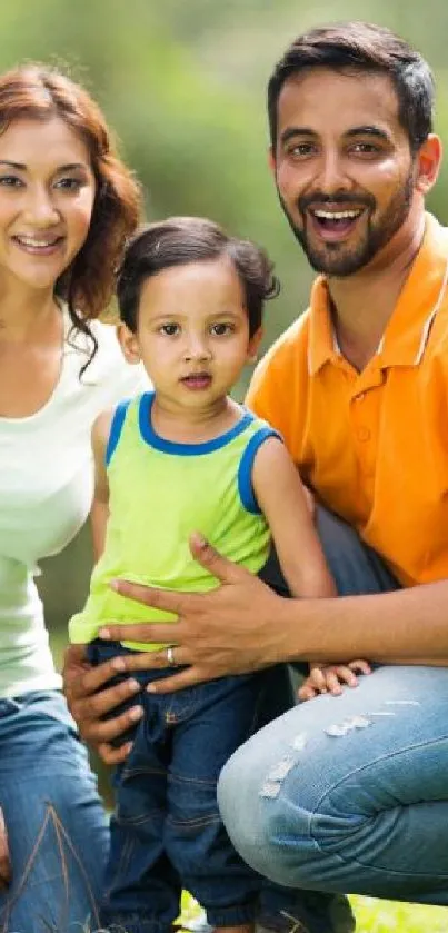 Happy family sitting on green grass in a sunny park.