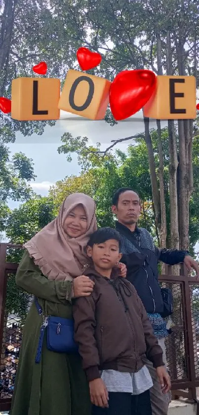 Family standing outdoors with love sign.