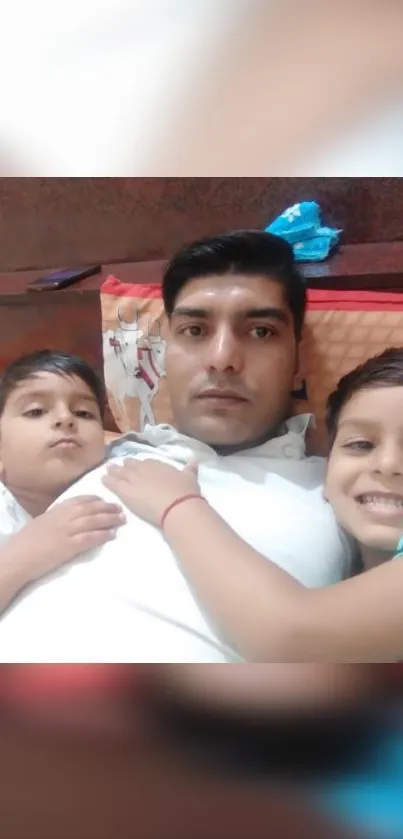 Father with two children on bed smiling.