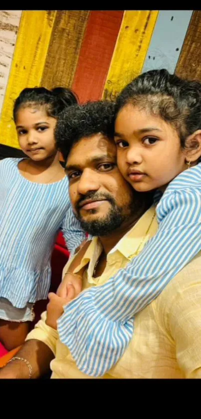 Smiling family with children embracing in a colorful background.