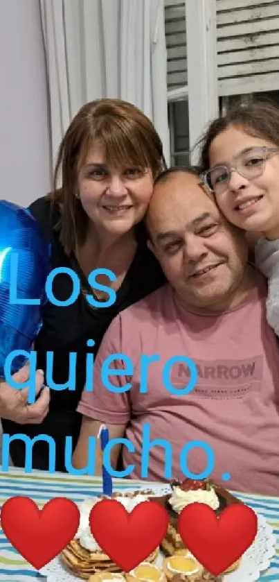 Family smiling with blue heart balloon and table setting.
