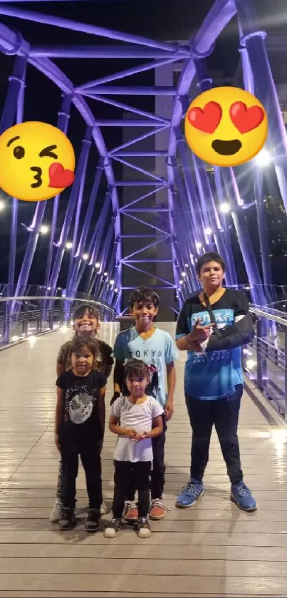 Family on a lit bridge at night with colorful emojis.