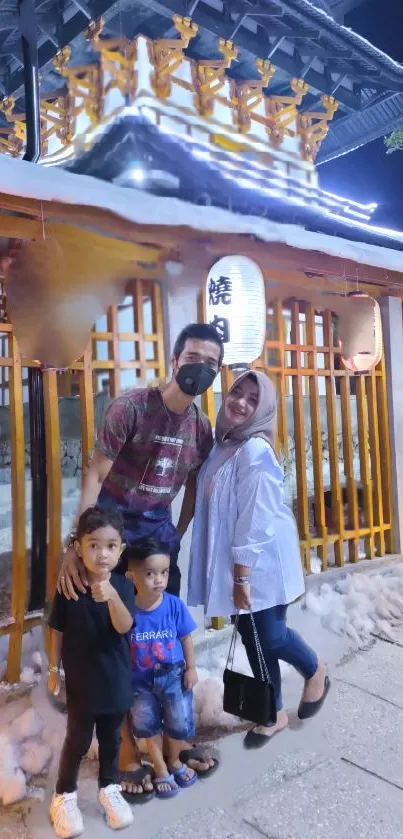 Family enjoying night at shrine, glowing in light.