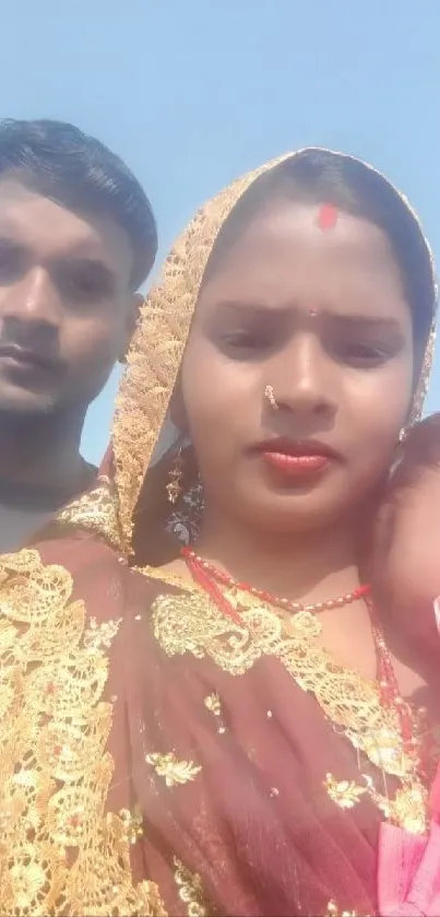 Family in traditional attire under clear blue sky.