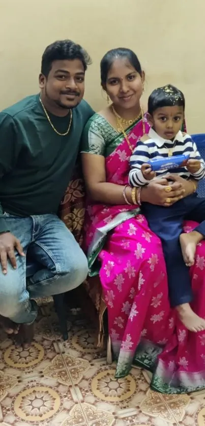 Family sitting in a room with vibrant attire and patterned flooring.