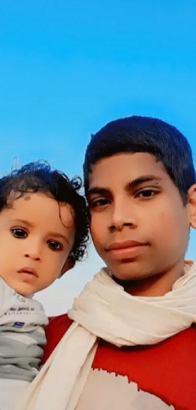 Family portrait with blue sky background, showing warmth and connection.