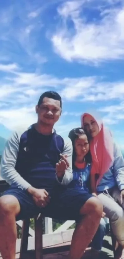 Family sitting outdoors with a scenic blue sky backdrop.