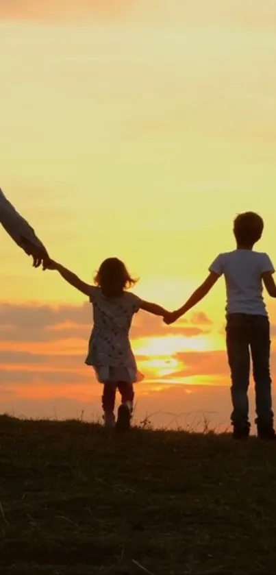 Family silhouette holds hands at sunset horizon, creating serene scenery.