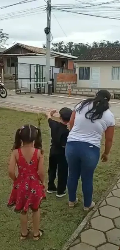 Family walking by countryside house on a calm day.