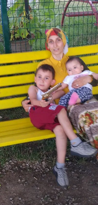 Family sitting on a yellow park bench, enjoying outdoor time.