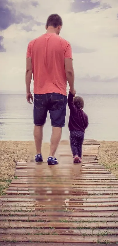 Father and child walking on a beach boardwalk towards the ocean.