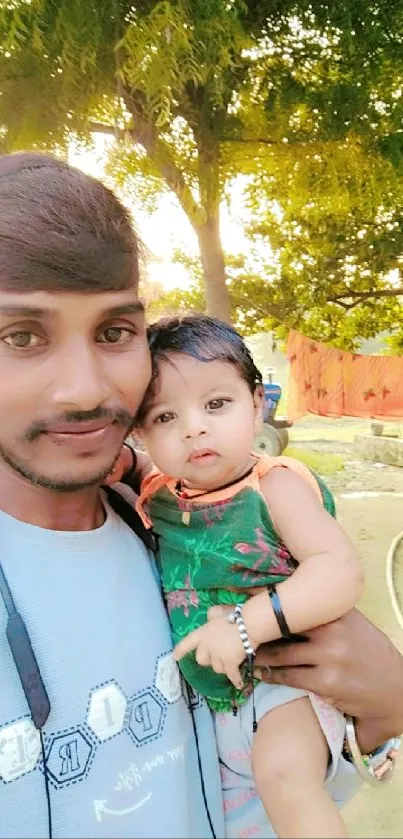 Father holding child in sunlight with nature background.