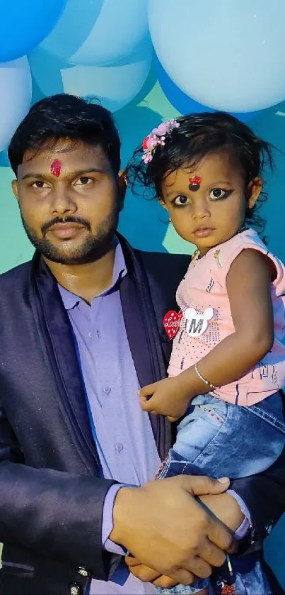 Father holding child in celebration, colorful decor.