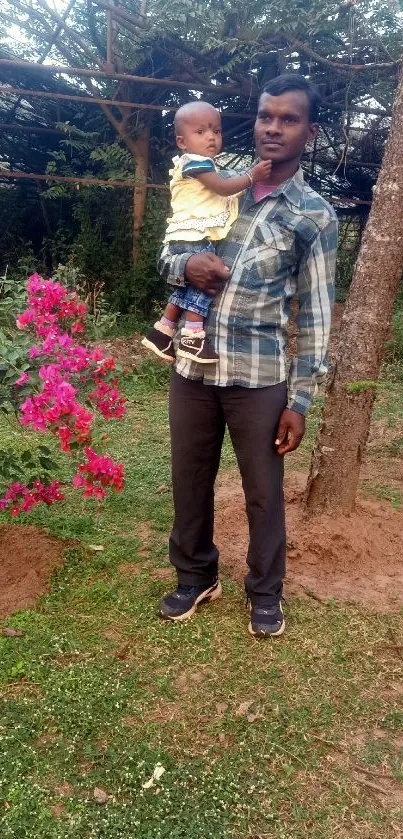 Father holding child in a vibrant garden.