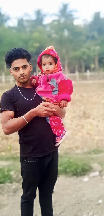 Father holding child in natural outdoor setting.