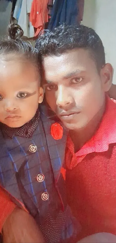 Father and child in red attire, sharing a moment.