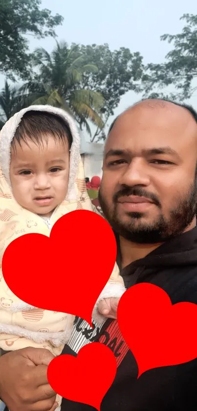 Father holding child with red hearts overlay.