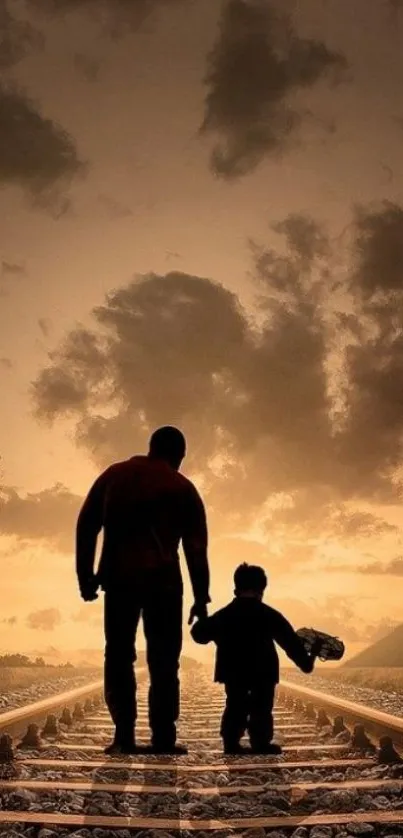 Silhouette of father and child walking along railway at sunset.