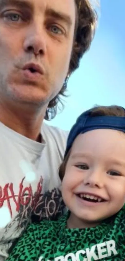 Father and child smiling with a blue sky background.