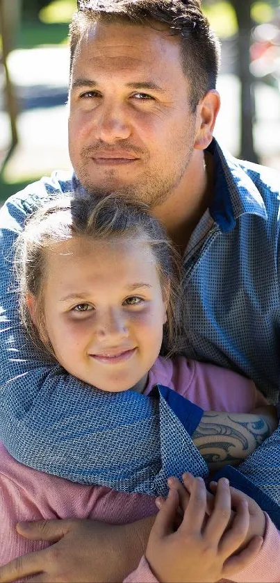 Father and daughter embracing in a sunny outdoor setting.