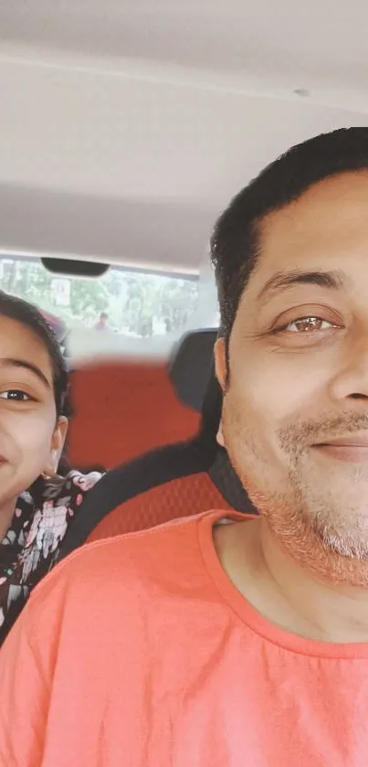 Father and daughter in a car, smiling together.