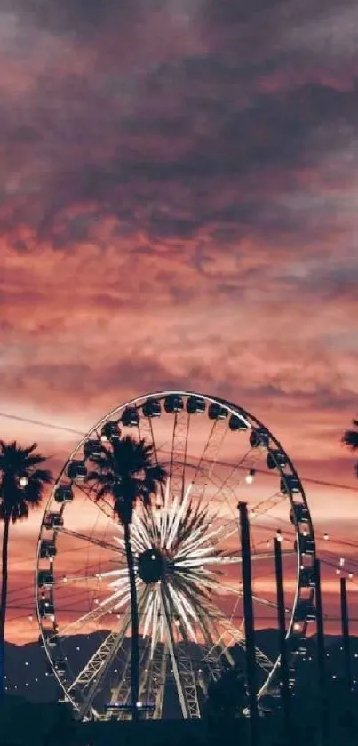 Ferris wheel and palm trees at sunset under a vivid pink sky.