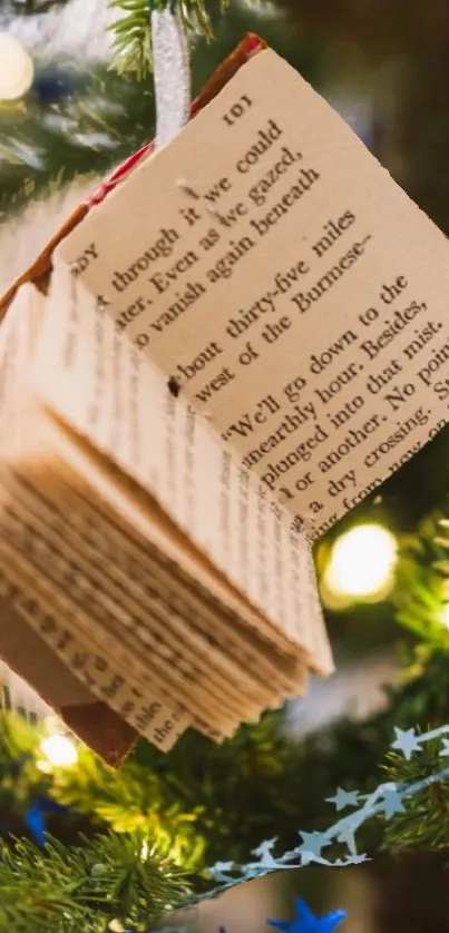 Open book ornament hanging on a colorful, decorated Christmas tree.