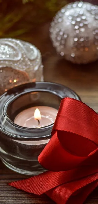 Festive scene with candles, ornaments, and red ribbon on a wooden table.