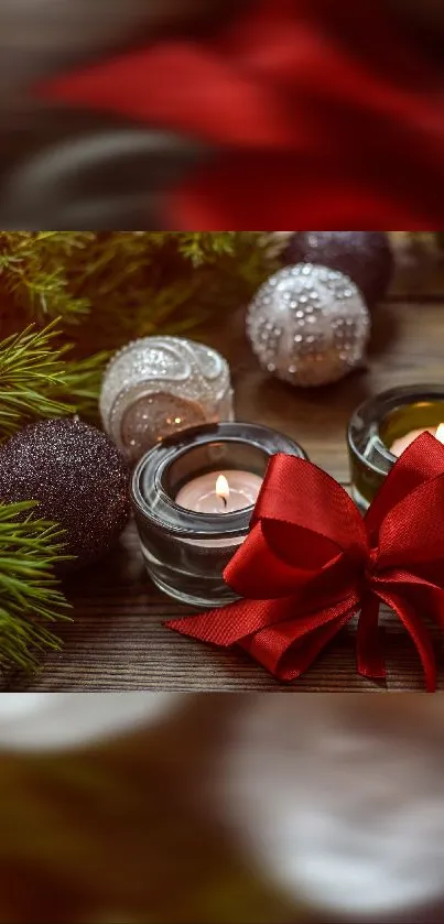 Candles with red ribbon and Christmas ornaments on a wooden table.