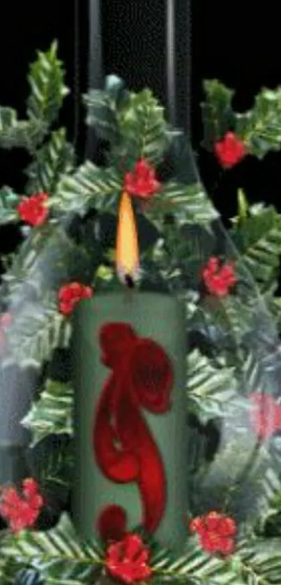 Glowing candle with holly leaves and berries in glass.