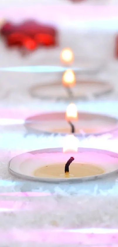 Festive wallpaper with red ornaments and glowing candles on white snow.