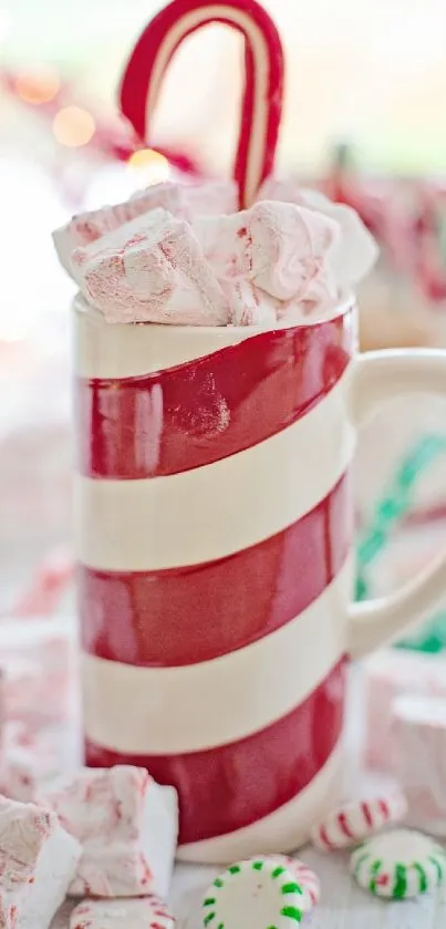 Festive striped mug with peppermint treats and candy cane.