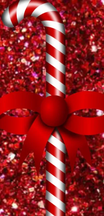 Candy cane with red ribbon on sparkling red background.