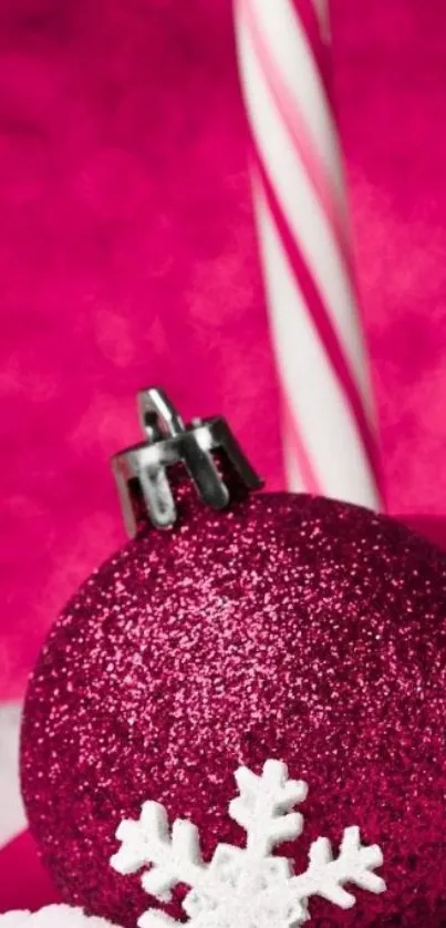 Pink festive wallpaper with glittery ornament and candy cane.