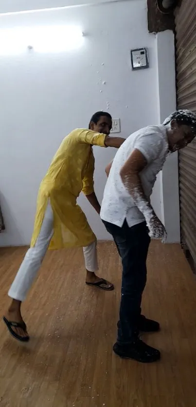 Two people celebrating playfully indoors in traditional attire.