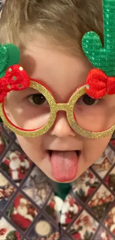 Child with festive glasses and playful expression against holiday background.