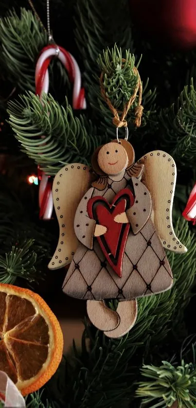 Wooden angel ornament with heart on Christmas tree.