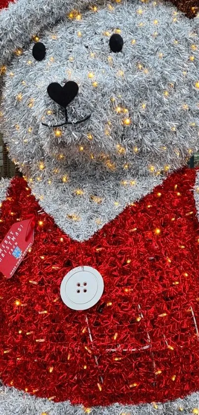 Festive teddy bear with red tinsel and holiday lights.