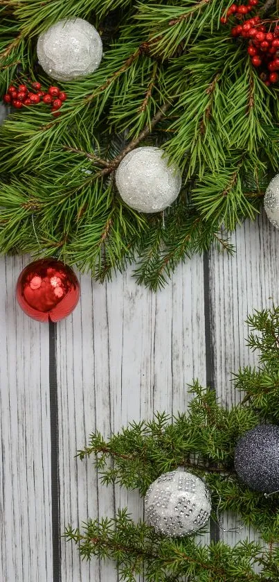 Christmas garland with red berries and ornaments on rustic wood.