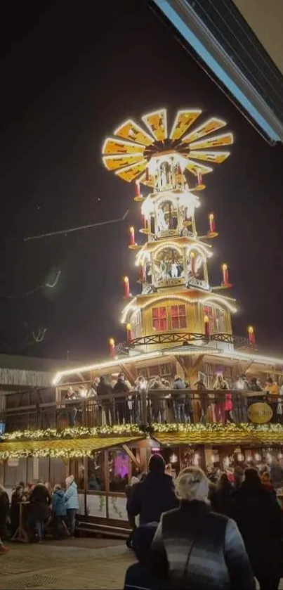 Festive Christmas market illuminated at night, bustling with visitors.