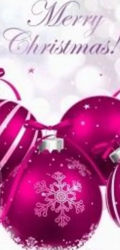 Pink Christmas ornaments on festive wallpaper.