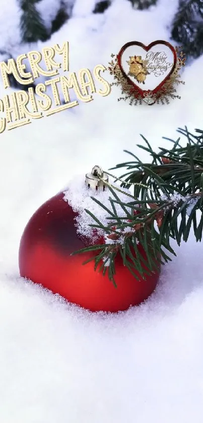 Red ornament in snow with Merry Christmas text and pine branches.