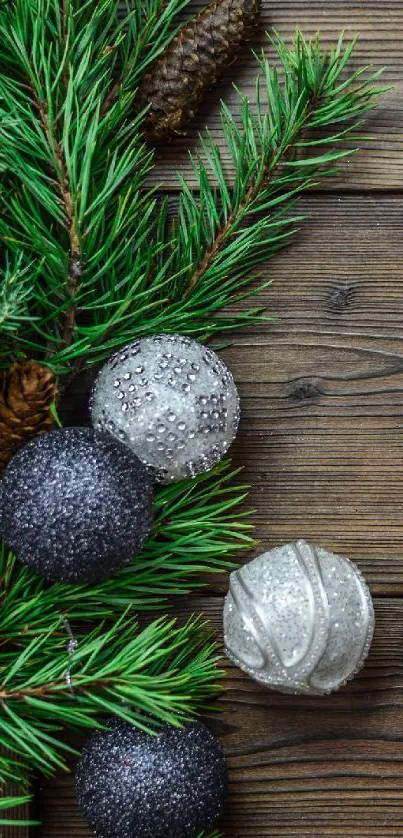 Festive Christmas wallpaper with pine, baubles, and candles on wood.