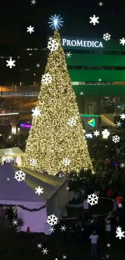 An illuminated Christmas tree at night surrounded by a festive crowd.