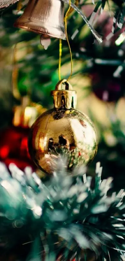 Close-up of Christmas tree with gold and red ornaments and green tinsel.