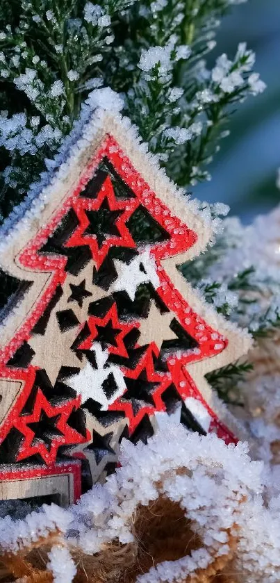 Wooden Christmas tree ornament with stars on snow-covered branches.
